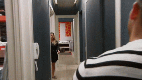 a woman stands alone in the hallway in a house