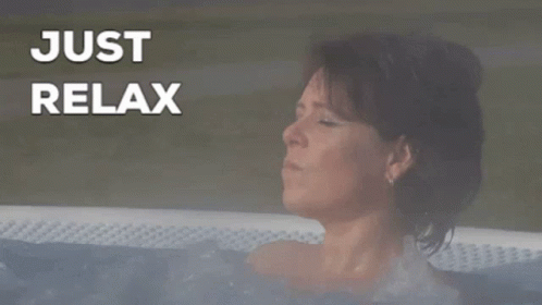 a woman is taking a bath in a white tub