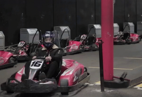 some people on small bumper car racings inside a parking lot