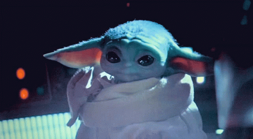 a baby yoda with a robe is holding soing