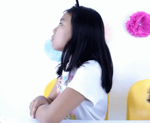 a child in a chair with fake hair on her head