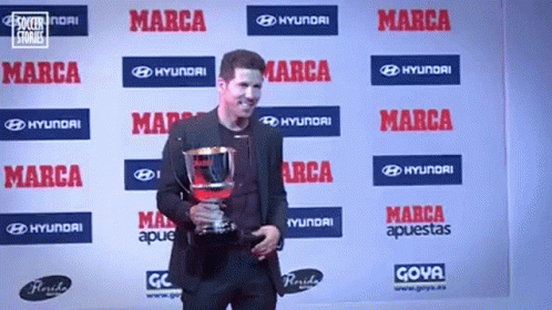the man is holding a trophy in his hand