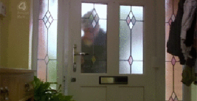 the reflection of a lady standing in the front door