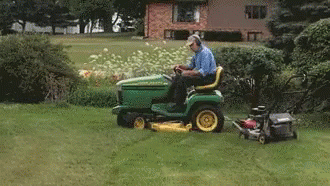 a man riding on top of a lawn with a lawn mower