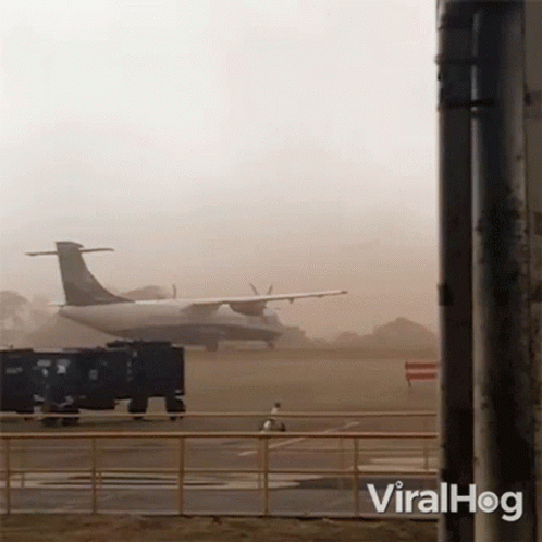 two airplanes on the runway, with a foggy background