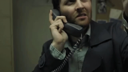 a man is talking on the telephone while he looks very confused
