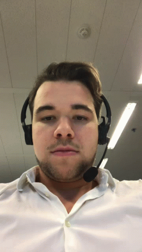 a man wearing headphones standing inside of an office building