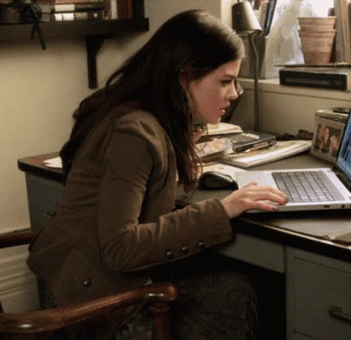 a young woman using a laptop computer at her desk