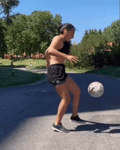 a man wearing shorts standing next to a soccer ball