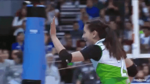 woman in a green outfit throwing a volleyball