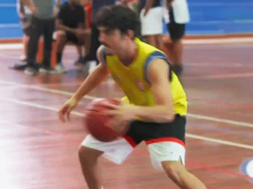 a male basketball player is about to pass the ball