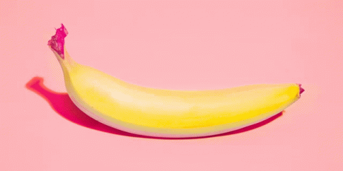 an unripe banana on a light background