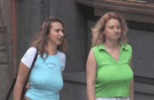 two women who are walking together in the street