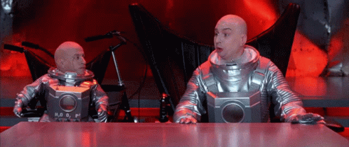 two men in robots suits sitting at a table