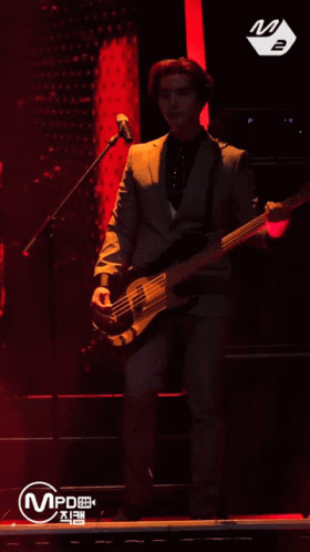 a person standing on a stage with a bass in front of him