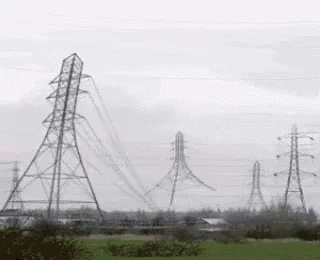 a power line in a field that appears to be on a cloudy day