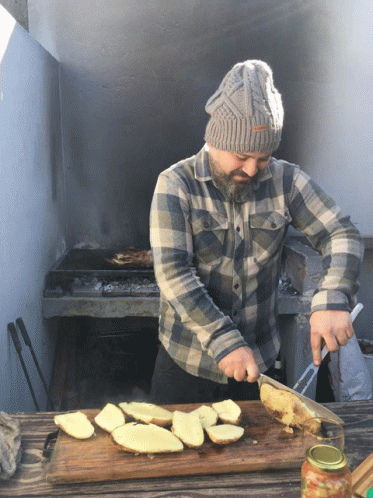 a person wearing a hat and jacket cooking food