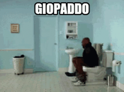 a man sits on a toilet in a yellow bathroom
