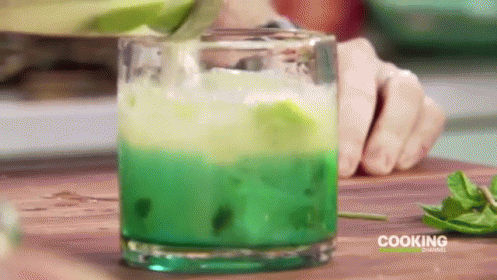 the two men are making a green and blue drink