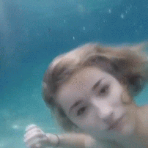 a girl with big tits is under water