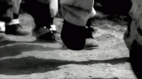a black and white po with someones feet in the sand