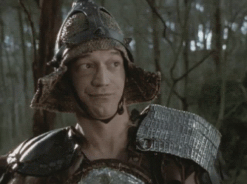 an older man wearing armor in the woods