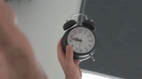 a hand holding a clock with soing on the face
