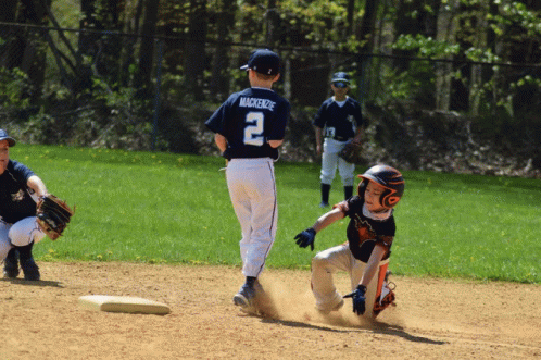 a boy in brown shirt chasing a baseball