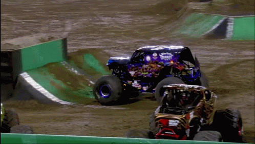 two monster trucks racing each other across a track
