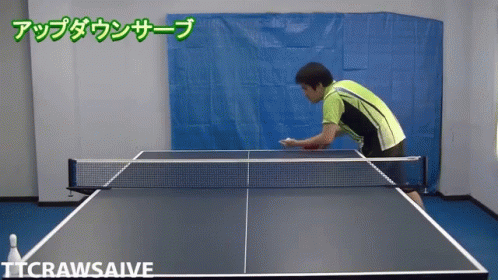 a man with an arm cast reaches down to hit a ping pong ball
