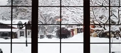 the window view is out onto a snow - covered village