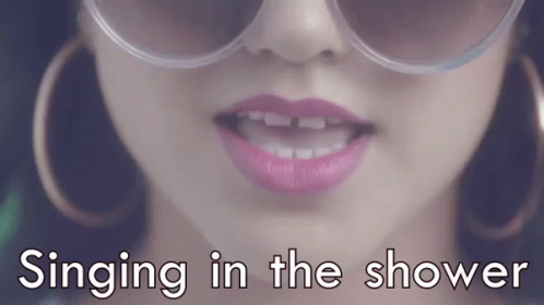 a lady wearing shades with the caption singing in the shower