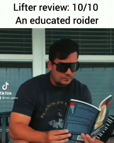 the man is reading a book while wearing glasses