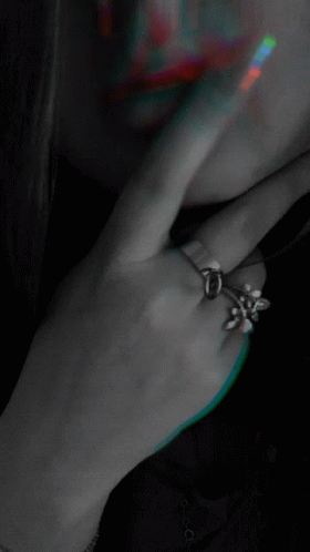 a woman's hand is next to her ear with an elegant ring