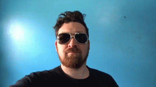 a man with a beard and sunglasses in a blurry pograph