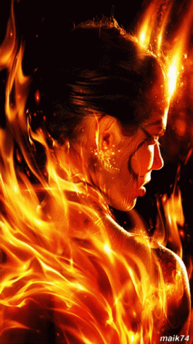 a woman wearing fire with glowing blue paint on her face and body