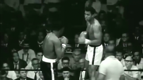 two boxers standing next to each other on a boxing ring