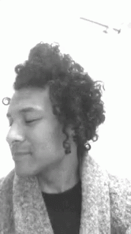 a person with curly hair looking away