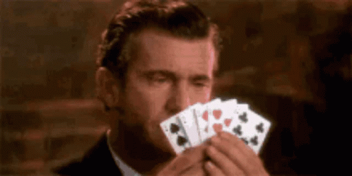 a man holding two cards and biting one with his mouth