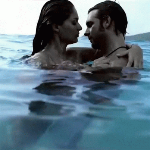 a couple swims through the water in the ocean