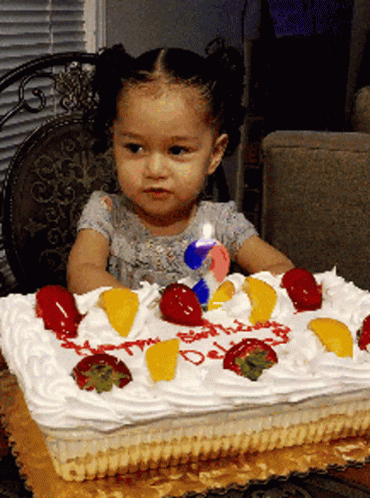a baby girl is sitting at her birthday cake