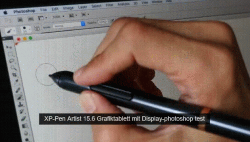 a hand holding a pen writing on a computer screen