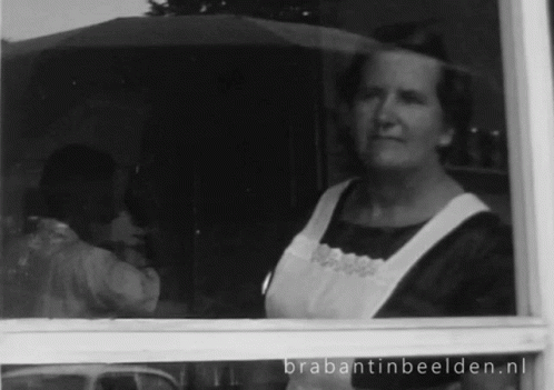 a black and white po of a lady looking out the window