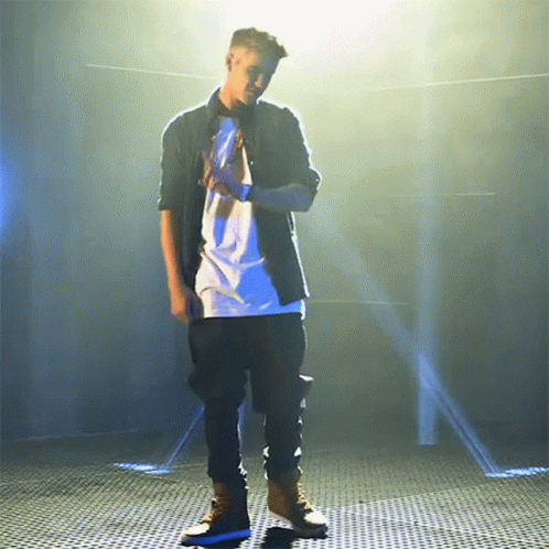 a man is standing on a stage in front of spotlights