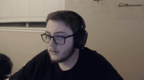 the man wearing a headset is looking at soing on a computer screen