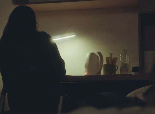 a dark silhouette of a woman in front of a bathroom mirror