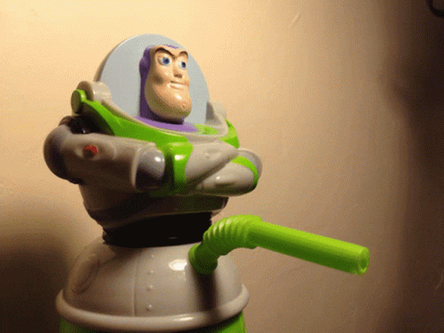 a toy is sitting in a space suit, holding an object