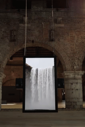 an art installation inside a stone arch with two light fixtures hanging over it