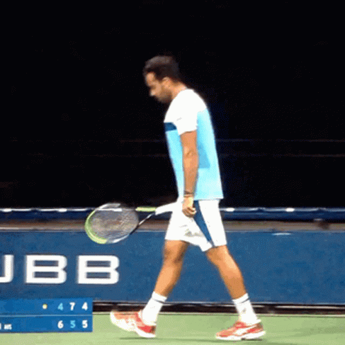 man in yellow and blue tennis uniform walking on court