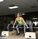 a woman doing an overhead barbell pull up exercise